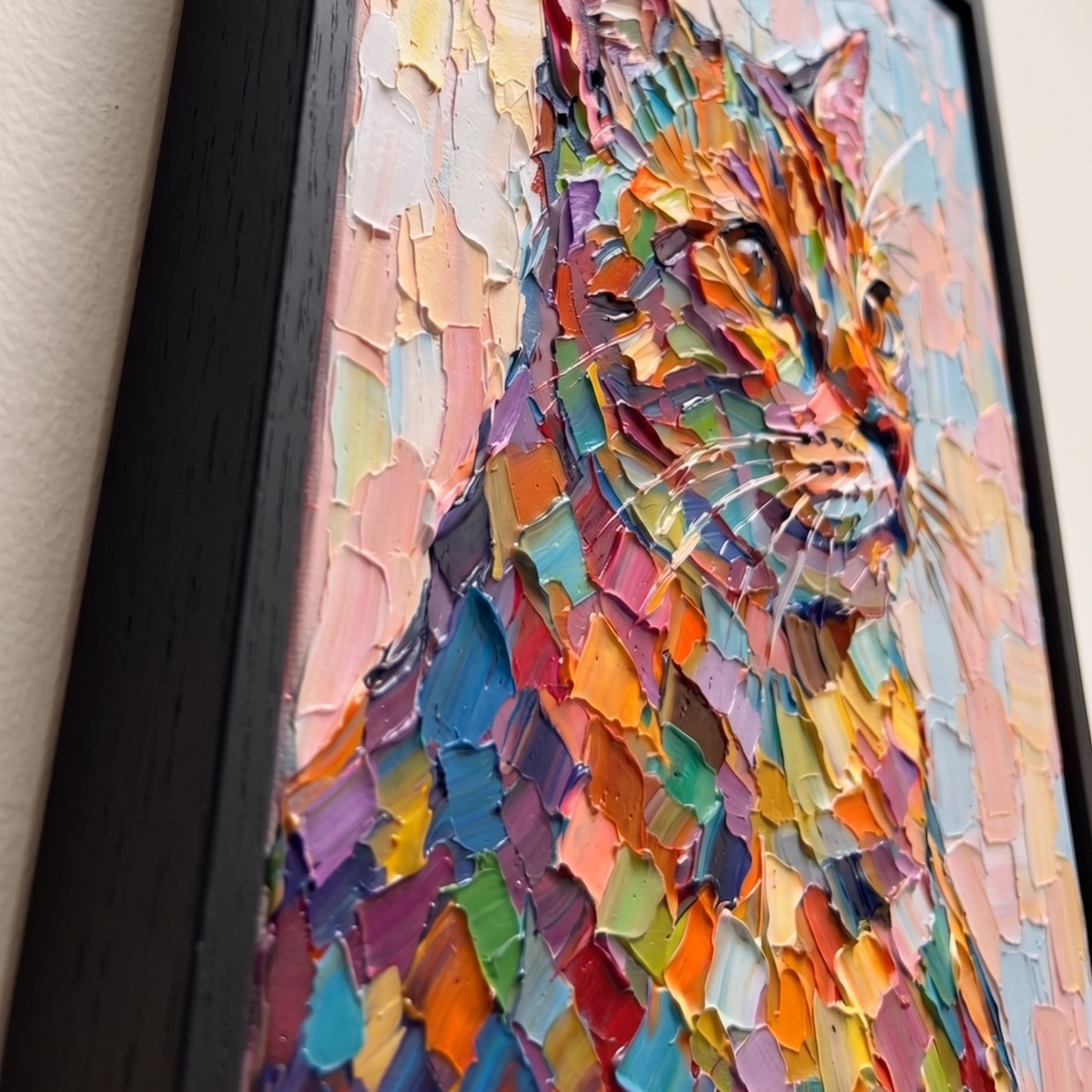 Extreme close-up side angle of the colorful cat painting, highlighting the thick 3D hand-embellished impasto palette knife textures and the floating gap of the matte black frame.